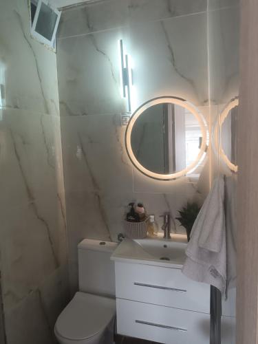 a bathroom with a toilet and a sink and a mirror at Zara's Boutique near Venizelos metro station in Thessaloniki