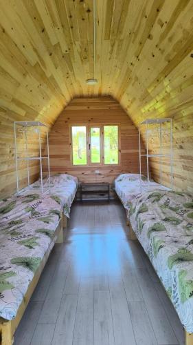 a room with four beds in a wooden cabin at Guesthouse Snow Leopard - 'Ak Ilbirs' in Tong