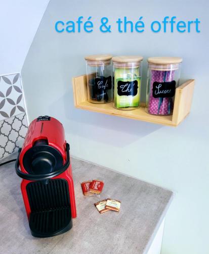 a red coffee maker sitting on a table with a shelf at Le Colombier in Wailly