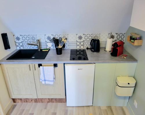 a small kitchen with a sink and a stove at Le Colombier in Wailly