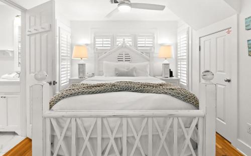 a white bedroom with a white bed and two lamps at Spice in Santa Rosa Beach