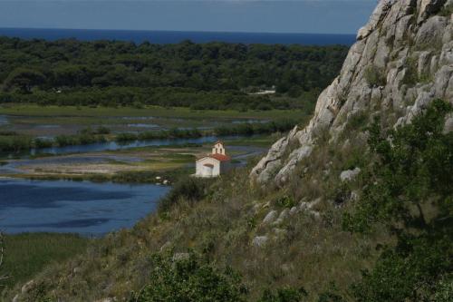 a small chapel on a hill next to a river at Verde Al Mare Boutique Hotel in Kalogria