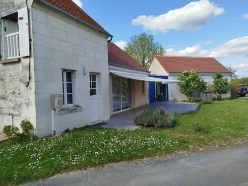Un edificio blanco con un patio con flores blancas. en LE LOGIS VINEA, en Pouillé