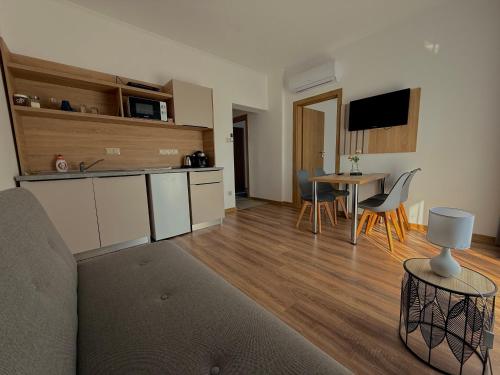 a living room with a kitchen and a table at Családi kikötő apartman in Gyula