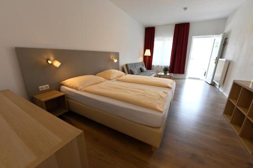 a bedroom with a large bed in a room at Hotel Garni Pension Gambrinus in Passau
