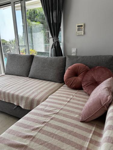 a couch with two pillows in a living room at HalCyon-On the blue in Nea Makri