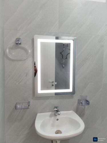 a mirror above a sink in a bathroom at Drymades Ruci Rooms in Dhërmi