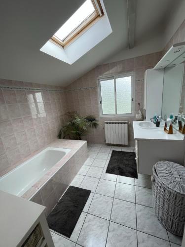 une salle de bain avec une baignoire et un lavabo dans l'établissement Villa avec piscine Anglet proche Biarritz, à BIQ