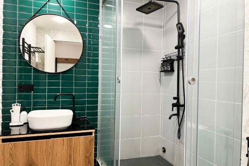a green tiled bathroom with a sink and a mirror at Rooms Apart Hotel by RED in Yerevan