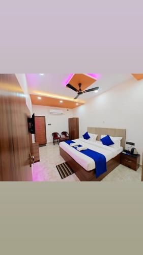 a bedroom with a large bed with blue pillows at Hotel The R L Palace - "A Luxurious Hotel" 900 Meters From Ram Mandir Ayodhya in Ayodhya