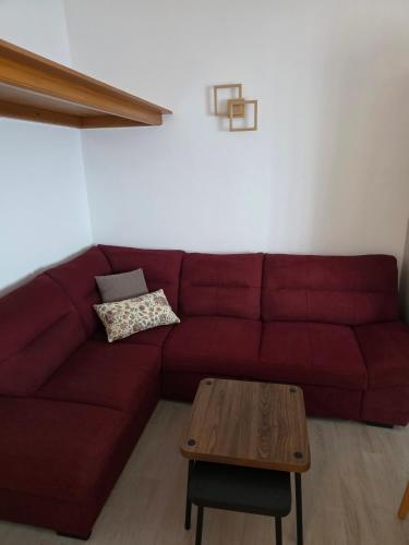 un canapé rouge avec une table basse dans un salon dans l'établissement Winery Bačić, à Blato