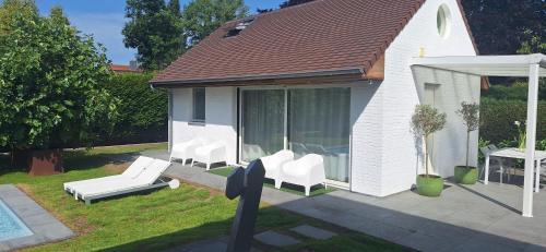 a group of white chairs sitting on a patio at Thibault1 in Gistel