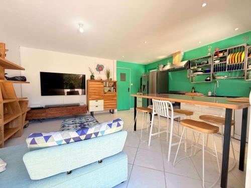 - un salon avec des murs verts, une table et des chaises dans l'établissement Sablonnette, à Saint-Georges-dʼOléron