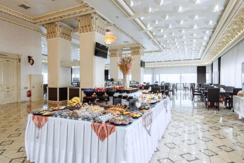 a buffet table with food on it in a large room at Daniel Hill Hotel in Tashkent
