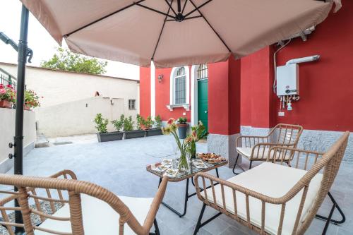 a patio with a table and chairs and an umbrella at Dimora Gioia in Ercolano