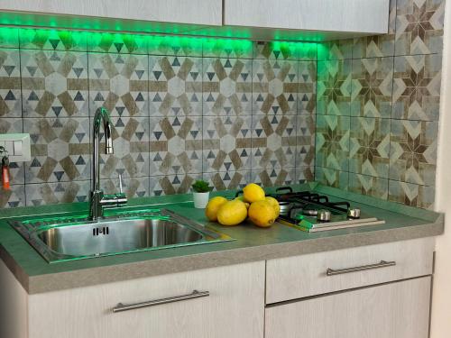 eine Küche mit Spüle und etwas Obst auf der Arbeitsplatte in der Unterkunft Osterio Holidays Cefalù in Cefalú