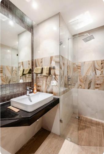 a bathroom with a sink and a glass shower at The Twilight Flora in Gurgaon