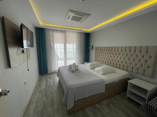 a bedroom with a large bed and a large window at Pasa Tatil Koyu in Akcaabat