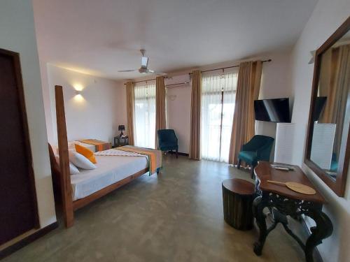 Dieses Hotelzimmer verfügt über ein Bett, einen Schreibtisch und ein Bett der Marke sidx sidx sidx sidx sidx. in der Unterkunft Rajini By The Waters in Tissamaharama