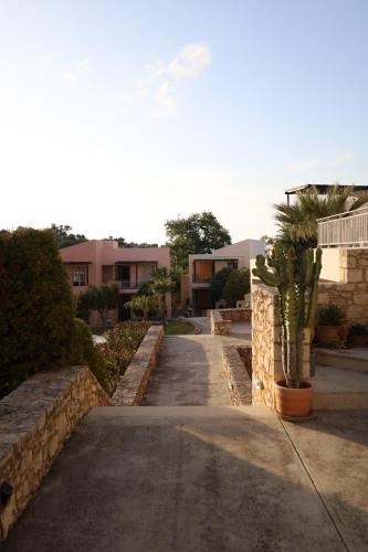 a pathway with a retaining wall and a cactus at Royal Touch Suite in Loutra