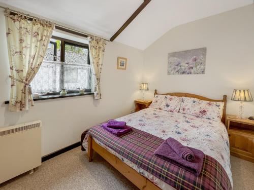 a bedroom with a bed and a window at Dairy Cottage Dulverton in Dulverton