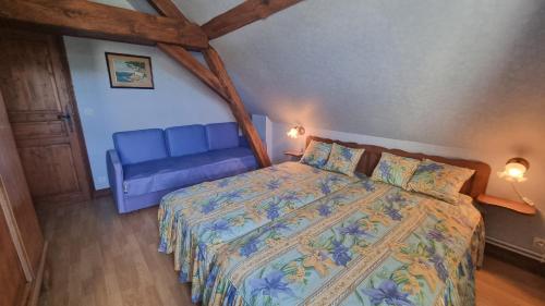 une chambre avec un lit et un canapé bleu dans l'établissement Appartement indépendant avec terrasse, à Bourré