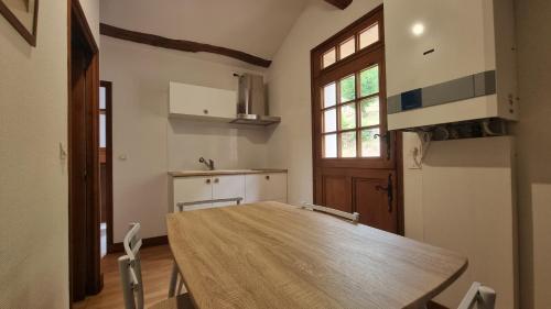 une cuisine avec une table et des chaises dans une pièce dans l'établissement Appartement indépendant avec terrasse, à Bourré