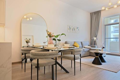 a dining room with a table and chairs and a couch at Air Homes - Stylish Urban Living in a Modern 1BR in Dubai
