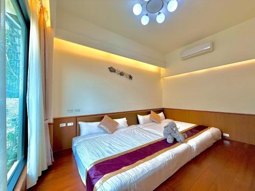 a bedroom with a bed with a teddy bear sitting on it at Kurumba JiJi B&B in Jiji