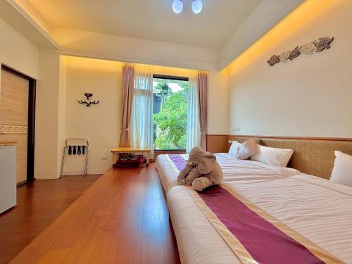 a teddy bear sitting on a bed in a bedroom at Kurumba JiJi B&B in Jiji