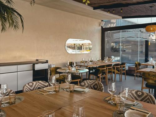 a restaurant with wooden tables and chairs and windows at Novotel Valencia Lavant in Valencia