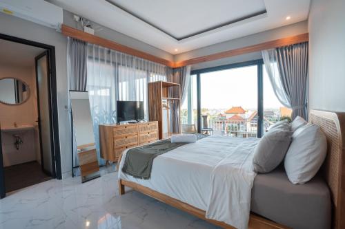 a bedroom with a large bed and a large window at Navee Studio Apartments Canggu in Munggu