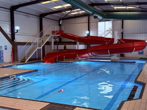 a large swimming pool with a red slide at Rathlin Apartment 1 bedroom in Ballycastle