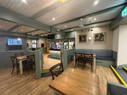 a restaurant with wooden tables and chairs and a bar at Rathlin Apartment 1 bedroom in Ballycastle