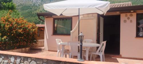a table and chairs with an umbrella on a patio at Michi's House Casa Vacanze in Maratea