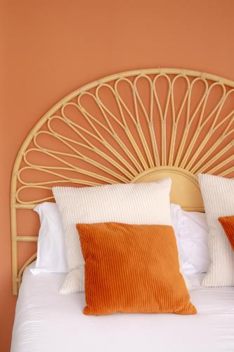 an orange and white bed with white pillows at SUPERTUBOS HOUSE Peniche in Peniche