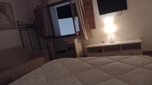 a bedroom with a bed and a light and a window at EL CHORRO Aire acondicionado Bar privado Barbacoa Amplios patios in Castalla