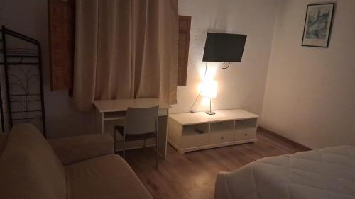 a bedroom with a bed and a desk with a lamp at EL CHORRO Aire acondicionado Bar privado Barbacoa Amplios patios in Castalla