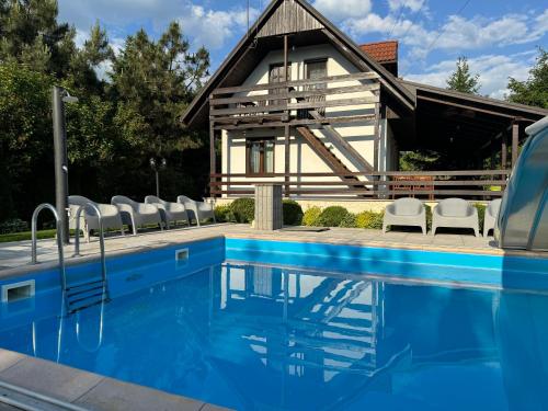 a house with a swimming pool in front of a house at Pokoje Irys in Kazimierz Dolny