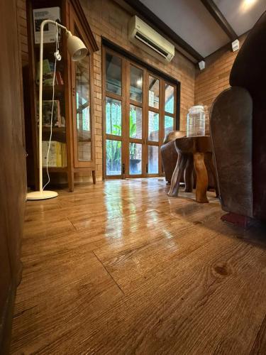 a living room with a wooden floor and a piano at Fresia Villa & Camping in Beranang