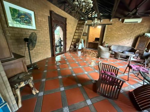 a living room with an orange tiled floor at Fresia Villa & Camping in Beranang