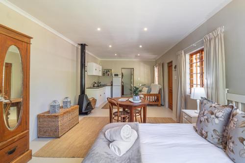 ein Zimmer mit einem Bett und eine Küche mit einem Tisch in der Unterkunft Hoogwater Cottage in Wolseley