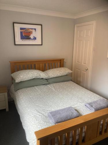 a bedroom with a wooden bed with two pillows at The Old Penny Bank in Barrow upon Humber