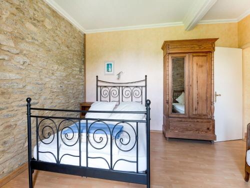 une chambre avec un lit et un mur en pierre dans l'établissement Luxurious Mansion in Castle Grounds in Lantheuil, à Lantheuil