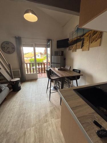 une cuisine avec une table et une salle à manger dans l'établissement Les Cottages 1 - Studio au bord de l'océan, à Biscarrosse