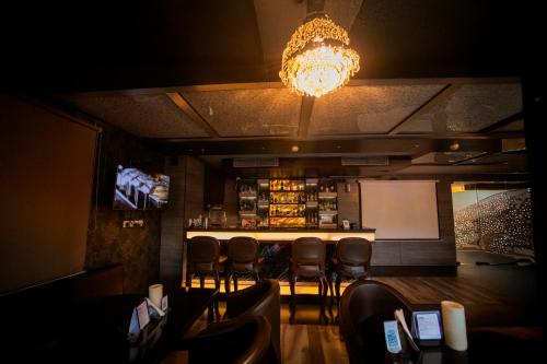 a bar in a restaurant with chairs and a chandelier at Ethnotel, Kolkata Airport in Kolkata