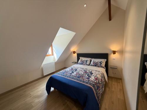 a bedroom with a bed with a blue blanket at Étage complet à la campagne in Chanzeaux