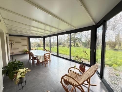 a screened in porch with a table and chairs at Étage complet à la campagne in Chanzeaux