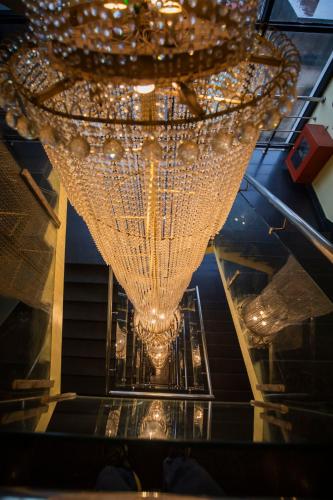 a large gold chandelier hanging from a ceiling at Ethnotel, Kolkata Airport in Kolkata