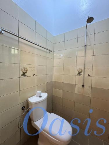 un bagno con un water con un cartello sul muro di Oasis a Cotonou